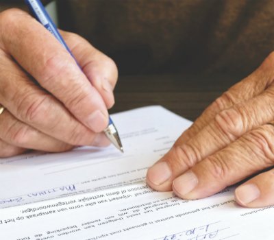A Man Signing a Form